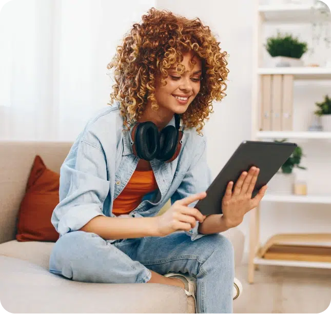Smiling woman using a tablet to explore personal loan options online. The process is safe, fast, and can be done from home.