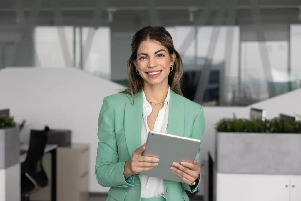 Woman holding a tablet in an office while learning how Fast Loan Advance works and exploring loan options